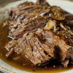 Side view of tender beef chuck roast drizzled with balsamic sauce.