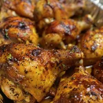 Side view of golden-brown chicken thighs coated in barbecue sauce, ready to be enjoyed.