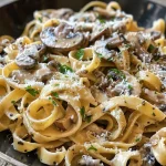 Juicy garlic mushroom pasta dish with a creamy texture and visible garlic and mushroom pieces.