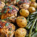 Appetizing roasted chicken breasts with herbs, potatoes, and green beans, beautifully arranged for a meal.