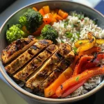 Close-up of a colorful chicken and vegetable power bowl featuring fresh ingredients.