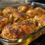 Juicy Baked Paprika Chicken garnished with herbs on a white plate.