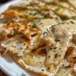 Delicious slice of Chicken Alfredo Quesadilla with visible mozzarella and alfredo sauce.