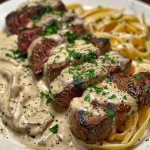 Close-up shot of creamy Cajun steak Alfredo in a bowl, garnished with chopped parsley.