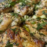 A side view of flavorful garlic herb chicken breast on a plate, showcasing its juicy texture.