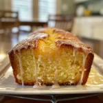 Close-up view of a glazed lemon pound cake loaf with a shiny lemon glaze.