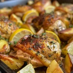 Succulent chicken thighs garnished with herbs and surrounded by roasted baby potatoes.