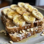 Close-up view of peanut butter banana toast topped with sliced bananas and hemp hearts.