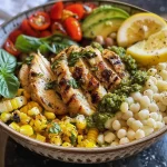 Detailed view of a colorful Pesto Chicken Bowl filled with cannellini beans and lemon wedges.