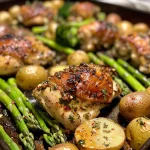 Juicy garlic butter chicken with colorful roasted veggies on a sheet pan.