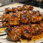 Appetizing Sweet Chili Chicken Skewers presented on a plate, garnished with herbs.