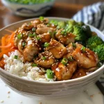 Close-up view of a Teriyaki Chicken Rice Bowl featuring bite-sized chicken, rice, and colorful vegetables.