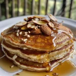 Close-up view of fluffy almond pancakes topped with spiced almond butter.