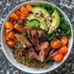 Juicy beef protein bowl with quinoa and colorful vegetables.