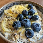 Close-up view of a bowl of Blueberry Lemon Overnight Oats topped with fresh blueberries and lemon zest.