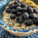 Close-up view of Blueberry Overnight Oats in a glass jar, showcasing layers of oats and blueberries.