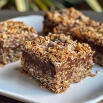 Close-up view of rich Chocolate Coconut Oat Squares, highlighting the texture and layers.