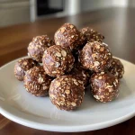 Close-up view of chocolate peanut butter energy bites on a wooden surface.