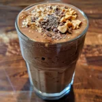 Close-up of a creamy Chocolate Peanut Butter Oatmeal Smoothie in a glass.