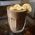 Close-up of a thick chocolate banana protein smoothie with a creamy texture.