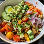 Close-up view of a vibrant lentil quinoa bowl with fresh vegetables and feta.