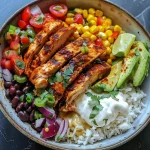 Close-up of a colorful Spicy Chicken Taco Bowl with rice, chicken, avocado, and vegetables.