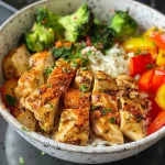 A close-up side view of a colorful chicken and veggie power bowl.
