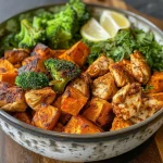 ['Juicy chicken thighs and roasted sweet potatoes arranged on a plate.', 'Close-up view of crispy chicken skin and cubed sweet potatoes garnished with herbs.', 'Side angle photo of a hearty meal featuring chicken and sweet potatoes.', 'Colorful dish of seasoned chicken thighs with sweet potatoes and onion.']