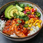 ['A close-up side view of a Chipotle Honey Salmon bowl featuring colorful ingredients.', 'Juicy salmon fillets glazed with honey and chipotle, surrounded by rice and fresh vegetables.', 'A beautifully arranged bowl with salmon, avocado slices, and vibrant toppings.', 'An appetizing bowl filled with honey chipotle salmon, rice, corn, and garnishes.']