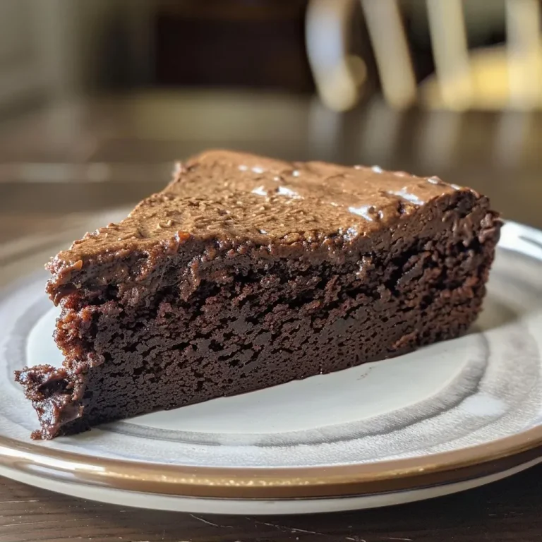['A side view of a moist chocolate protein cake showcasing a rich chocolate frosting.', 'Close-up of a chocolate protein cake with a glossy frosting, revealing its layered texture.', 'A slice of chocolate protein cake from the side, highlighting the fluffy interior and smooth chocolate covering.', 'Juicy chocolate protein cake displayed at an angle, accentuating its decadent appearance.']