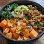 ['A close-up view of a ground turkey sweet potato bowl with vibrant colors.', 'A hearty bowl filled with seasoned ground turkey, diced sweet potatoes, and fresh greens.', 'A side view of a delicious ground turkey and sweet potato dish garnished with avocado.', 'An appetizing ground turkey sweet potato bowl with a mix of ingredients ready to enjoy.']