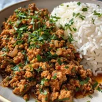 ['Close-up view of juicy ground turkey served over garlic butter rice, garnished with fresh parsley.', 'Side view of a plate featuring ground turkey with garlic butter rice, highlighted with diced onions and herbs.', 'Tantalizing ground turkey and garlic butter rice dish, showcasing a mix of textures and colors.', 'Appetizing ground turkey mixed with garlic rice, captured in a close-up with vibrant ingredients.']