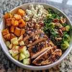['Close-up view of a colorful Harvest Bowl featuring grilled chicken, butternut squash, and vibrant greens.', 'Side view of a Harvest Bowl filled with brown rice, kale, cranberries, almonds, and Parmesan cheese.', 'A detailed shot of a Harvest Bowl showcasing sliced chicken breast, roasted butternut squash, and fresh kale.', 'Vibrant Harvest Bowl with layered ingredients including chicken, butternut squash, and a sprinkle of nuts.']
