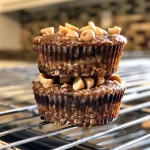 ['Close-up view of Healthy Chocolate Peanut Butter Banana Muffins with a moist texture.', 'Side view of freshly baked chocolate peanut butter banana muffins, showcasing their rich color.', 'Juicy and fluffy chocolate peanut butter banana muffins displayed on a surface.', 'Delicious muffins made with bananas, chocolate, and peanut butter, highlighting their inviting appearance.']