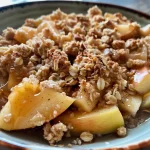 ['Close-up view of a warm, golden-brown apple crumble topped with oats and melted butter.', 'Side angle shot of high-protein apple crumble with apples, oats, and a sprinkle of cinnamon.', 'Juicy apple crumble in a bowl, showcasing a crunchy oat topping and apple chunks.', 'High-protein apple crumble displaying caramelized apples and a crispy oat layer.']