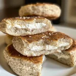 ['A close-up side view of golden brown high-protein bagel bites, showcasing their fluffy texture.', 'Juicy high-protein bagel bites arranged on a plate, highlighting their savory seasoning and sesame topping.', 'Freshly baked bagel bites with a moist interior and crunchy exterior, emphasizing their delicious ingredients.', 'Side view of a platter of high-protein bagel bites, revealing a golden crust and inviting texture.']