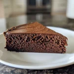 ['A side view of a rich chocolate cake with a smooth texture, showcasing a moist slice revealing its inside.', 'Close-up of a chocolate cake slice, highlighting a glossy chocolate exterior with a creamy filling.', 'A detailed view of a high protein chocolate cake, emphasizing its fluffy layers and decadent appearance.', 'A luscious chocolate cake slice with a shiny surface and soft interior, served on a plate.']