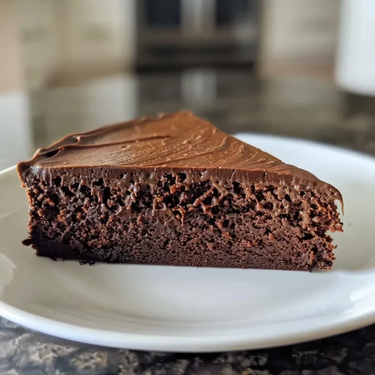 ['A side view of a rich chocolate cake with a smooth texture, showcasing a moist slice revealing its inside.', 'Close-up of a chocolate cake slice, highlighting a glossy chocolate exterior with a creamy filling.', 'A detailed view of a high protein chocolate cake, emphasizing its fluffy layers and decadent appearance.', 'A luscious chocolate cake slice with a shiny surface and soft interior, served on a plate.']