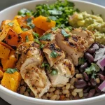 ['Close-up of a roasted chicken and butternut squash rice bowl topped with guacamole.', 'Colorful rice bowl featuring juicy roasted chicken, butternut squash, and fresh guacamole.', 'Side view of a bowl filled with brown rice, roasted chicken, and vibrant butternut squash.', 'Delicious rice bowl showcasing diced butternut squash and chicken with a garnish of cilantro.']