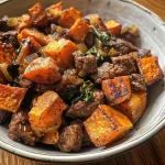 ['A close-up view of a colorful Sweet Potato Beef Bowl with vibrant ingredients.', 'Juicy beef and sweet potato mixture garnished with greens in a bowl.', 'Side view of a Sweet Potato Beef Bowl showcasing its hearty ingredients.', 'A delicious-looking Sweet Potato Beef Bowl filled with ground beef and spices.']