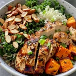 ['Close-up of a Chicken Harvest Bowl featuring colorful ingredients.', 'Side view of a Chicken Harvest Bowl with sweet potatoes, chicken, and kale.', 'Vibrant Chicken Harvest Bowl filled with diced apples and almonds.', 'Detailed view of a Chicken Harvest Bowl showcasing fresh greens and grains.']