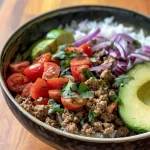 ['A beautifully arranged Turkey Taco Rice Bowl featuring slices of avocado and vibrant pico de gallo.', 'A close-up view of a Turkey Taco Rice Bowl with colorful toppings including avocado and fresh tomatoes.', 'A side view of a Turkey Taco Rice Bowl, showcasing ingredients like basmati rice, ground turkey, and avocado.', 'An appetizing Turkey Taco Rice Bowl garnished with pico de gallo and avocado, highlighting its vibrant colors.']