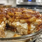 ['Close-up image of creamy Baked Caramel Apple Cheesecake Dip with caramel drizzle.', 'Side view of a delectable Baked Caramel Apple Cheesecake Dip topped with caramel.', 'Close-up of Baked Caramel Apple Cheesecake Dip in a bowl, featuring apple pie filling.', 'Rich and creamy cheesecake dip with caramel and apple topping in a serving dish.']