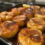 ['Close-up view of baked cinnamon and sugar apples, showcasing their golden-brown color and gooey texture.', 'Side angle of juicy, caramelized apples sprinkled with cinnamon and sugar, served in a dish.', 'Delicious baked apples glistening with a buttery cinnamon-sugar mixture, captured in a close-up shot.', 'Tasty baked apples arranged neatly, highlighting the warm, soft interior and sweet glaze.']