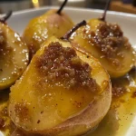['Close-up of baked pears caramelized with honey and brown sugar.', 'Juicy baked pears with a glaze and topped with chopped nuts.', 'Golden brown baked pears arranged elegantly on a plate.', 'Side view of delicious baked pears with a drizzle of honey.']