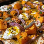 ['Close-up view of Butternut Squash & Burrata Flatbread topped with crispy sage leaves.', 'Side view of a flatbread with roasted butternut squash, burrata cheese, and sage.', 'Detailed image of a Butternut Squash flatbread garnished with fried sage and sliced red onions.', 'Juicy butternut squash and burrata flatbread presented for enjoyment, with crispy sage on top.']