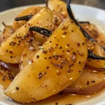 ['Close-up view of spiced chai poached pears arranged attractively on a plate.', 'Juicy pears poached in chai spices, garnished and presented in a side profile.', 'A side view of sliced pears soaked in chai syrup, displaying rich colors and textures.', 'Chai poached pears elegantly plated, showcasing the glistening pear syrup.']