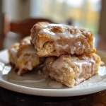 ['Close-up view of glazed cinnamon scones with a golden-brown exterior and a shiny glaze on top.', 'Side view of freshly baked cinnamon scones, glistening with a sweet glaze and sprinkled with cinnamon.', 'Mouthwatering glazed cinnamon scones, showcasing their flaky texture and juicy filling.', 'Detailed image of warm cinnamon scones with a glossy icing, highlighting the layers of flaky pastry.']