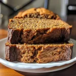 ['Close-up of a slice of moist pumpkin banana bread with a golden-brown crust.', 'Side view of healthy pumpkin banana bread showing texture and ingredients.', 'A juicy slice of no-added-sugar pumpkin banana bread on a wooden surface.', 'Delicious pumpkin banana bread with a rich, spiced topping served on a plate.']