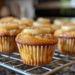['A side view of a pear cupcake topped with honey buttercream frosting.', 'Close-up of a delicious pear cupcake adorned with creamy honey buttercream.', 'Juicy pear cupcake with a swirl of honey buttercream on top, viewed from the side.', 'A moist pear cupcake featuring luscious honey buttercream, shown in a close-up shot.']